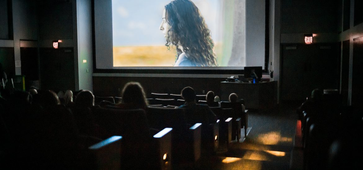 woman on a movie screen in front of audience