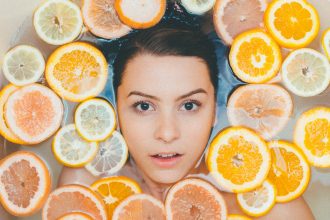 Woman in bathtub surrounded by sliced oranges