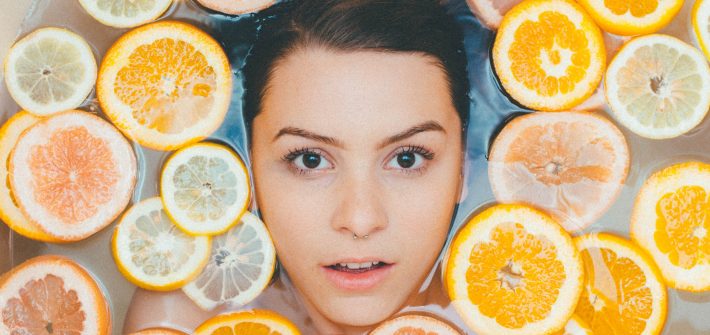 Woman in bathtub surrounded by sliced oranges