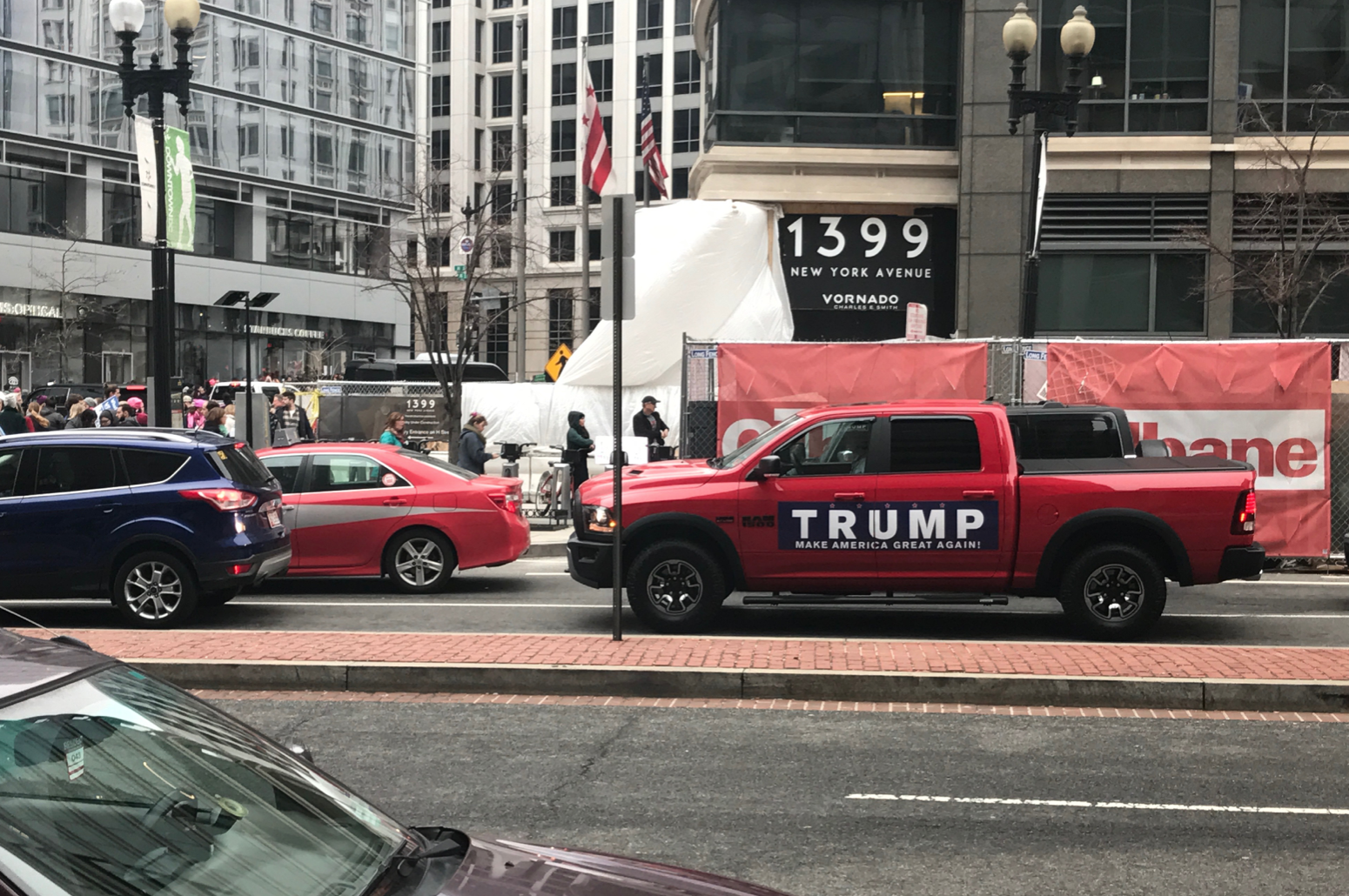A middle-aged couple drives around in a ‘TRUMP truck.’ We witness them turn around to avoid getting stuck in the crowd. The woman in the passenger seat recorded a video of the marchers on her phone.