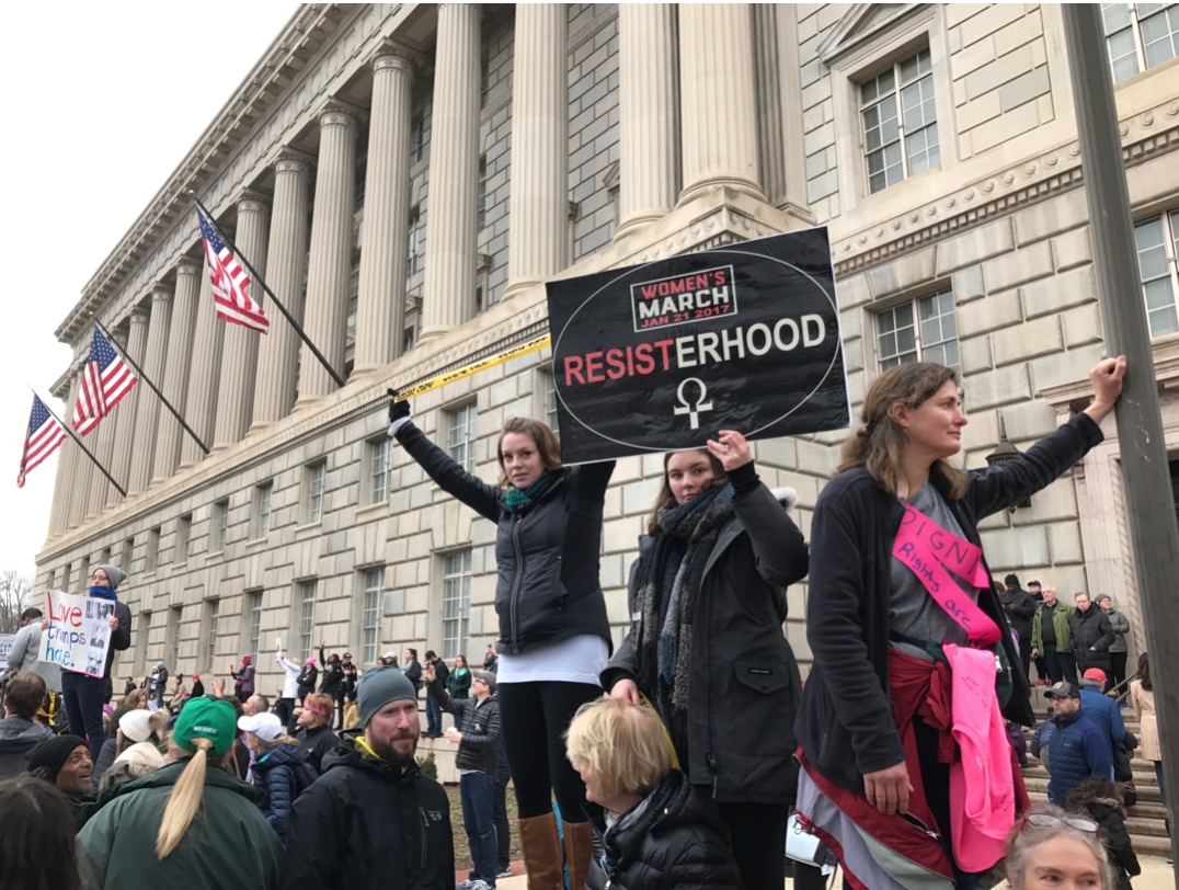 Washington, 1/21: Women at the march stand tall, raising “Resisterhood” signs and caution tape that reads ‘f*ck off!’